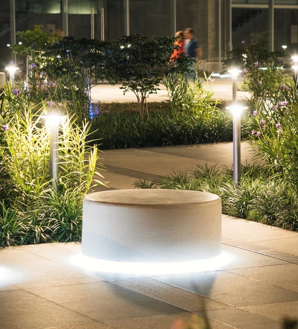 Mobiliario de concreto iluminado en un jardín